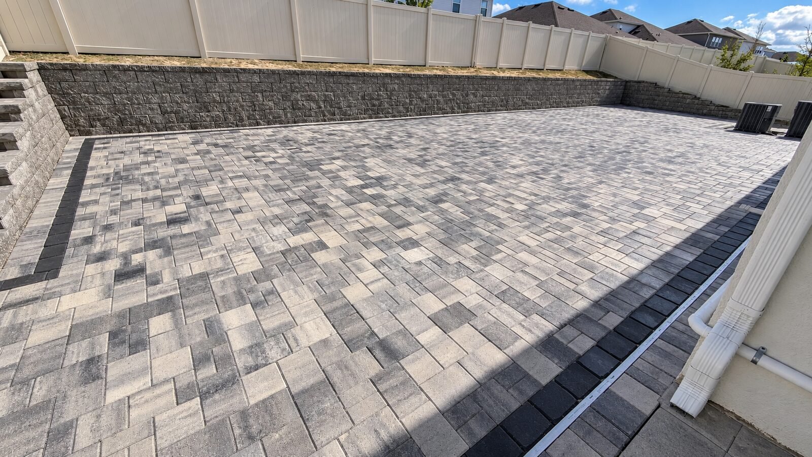 Detalle de esquina de patio de adoquines y muro de contención, instalados por Cavisa Solutions