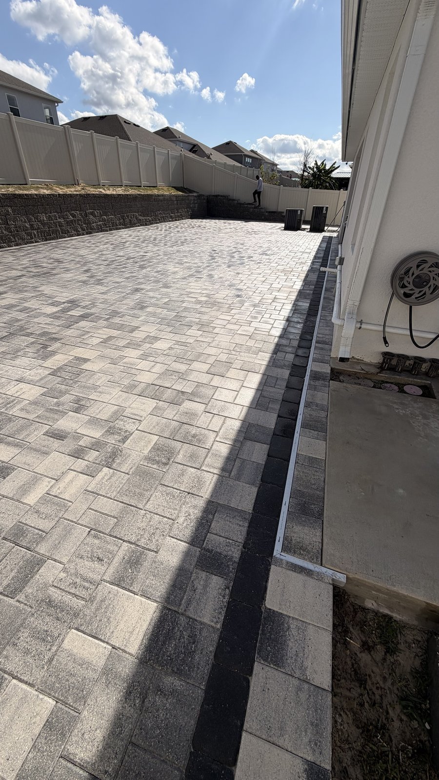 Side yard paver patio next to a retaining wall